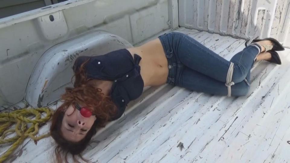 BITCHY MODEL THROWN IN THE BACK OF A PICKUP Sexy model Shelly Dare shows up for the modeling gig wearing skin tight denim jeans, a tiny crop top and sexy stiletto high heels. She's a total bitch right from the start telling me to hurry up with the photos since she's in a hurry to get to her next gig. She's such an uppity snotty brat girl that she quits posing mid-stream and storms to the door in anger. I call out to Jim Hunter to grab her ass and get her back inside. He rushes out and returns with the haughty model's arms brutally bound behind her back-his signature tie-her elbows welded together as if they're glued. He forces her down on the couch and I bend over to bind her knees together and straddle the bimbo and shove a big ballgag into her big uppity mouth silencing the bitch. We force her to hop out of the room in her bondage, but when we tire of this, Jim lifts and carries her outside and puts the bound beauty into the back of the pickup and off we go ... the next she knows Shelly finds herself being dragged into an abandoned building and forced up against a board. The next thing she knows her arms are being stretched and bound overhead to a ring in a board. The poor things twists and struggles and cries to be let go, but we shove a rag between her lips and seal it in good and tight with duct tape. Uppity bitch can't complain noow!!! Jim ties her ankles tightly together and we watch her struggles and cry. Guess it doesn't pay to be a bitchy model, does it Shelly??<br>https://www.clips4sale.com/studio/63805/14883445/BITCHY MODEL THROWN IN THE BACK OF A PICKUP_HD