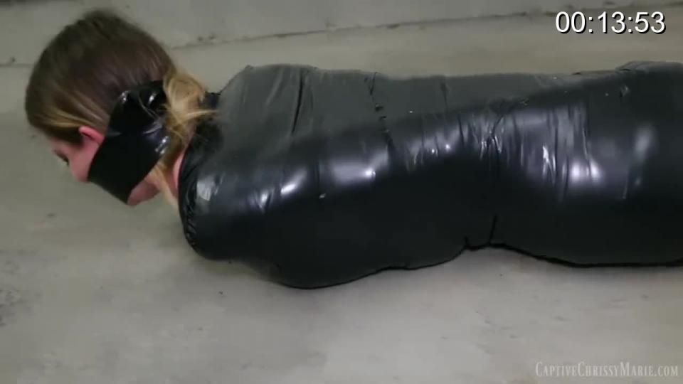 Mummified Misfortune Mummified Misfortune<br>From: Captive Chrissy Marie <br><br>Chrissy Marie is trying to find a way out of the house she was going to rob since it turns out they don't have anything valuable, but unfortunately for her she doesn't get out in time! She gets caught by the home owner who doesn't believe her sorry excuses and threatens to call the police! She begs him not to call the cops as he checks her out in her shiny black leggings, crop top, and super high heels. All that shiny black fabric has him thinking about what she would look like wrapped up tight in the electrical tape he happens to have on hand! He tells her he needs to secure her until he figures out whether or not he is going to turn her in. She lets him tape her wrists, thinking that it's not so bad and definitely better than going to jail! But then he keeps adding more tape, and when she starts to complain, he stuffs her mouth full and wraps the black tape extremely tight around her mouth and head so that she can barely make any noise! Now Chrissy is really scared and didn't realize what she was getting into! Maybe she would have been better off just letting him call the police! He keeps wrapping her up until she is mummified torturously tight and extremely distressed! She is then left alone as she attempts to struggle in her completely helpless predicament!<br><br>*Once I was fully mummified I quickly noticed that I could only take in small breaths of air with my waist and ribcage being wrapped so incredibly tight! The restricted breathing and intense bondage combined caused some very real suffering that shows!<br><br>https://www.clips4sale.com/studio/98213/18261018/Mummified Misfortune HD MP4