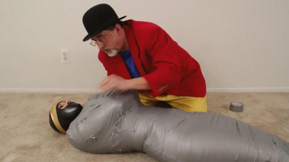 Wonder Woman's Wrapped Woes starring Jamie Knotts Note:  this video features Jamie's FIRST EVER duct tape mummification!  Wonder Woman managed to foil Dr. Primary's nefarious plans by shorting out the time bomb with her super saliva, but that does not mean she has escaped his clutches!  Still bound and gagged, her lovely face sealed in a vinyl hood and her body encased in panty hose, Wonder Woman can only listen helplessly as the evil genius reveals his next plan for her.  He plans to turn her into a living mummy!  Band after band of super strong duct tape encircles her body, her chances of escape dwindling with each circuit of the fiendish material.  Soon, she's completely cocooned!  She's left to struggle, feebly trying to gain freedom, until Dr. Primary returns to inform her of her fate:  She is to be carted off to the Gotham Museum of Archaelogy and sealed forever in a sarcophagus, a permanent display item!  Will she manage an escape?  Will anyone discover her plight?  Is there any hope for our daring diva?<br><br>https://www.clips4sale.com/studio/109778/17223314/Wonder Woman's Wrapped Woes starring Jamie Knotts (MP4 Format)