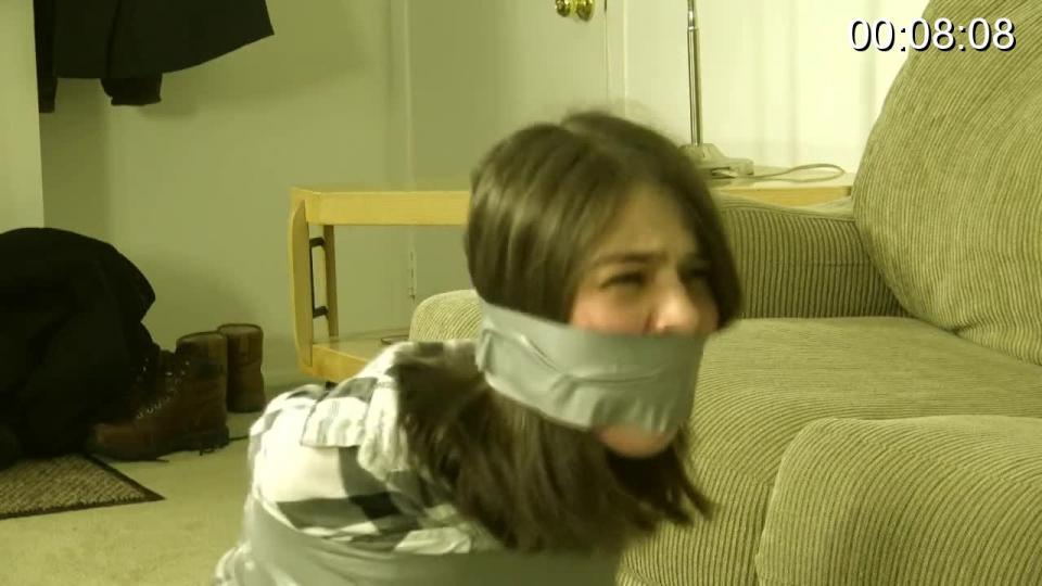 Jeanette Cerceau - Taped Tied Over A Television Jeanette is awfully proud of the con job she pulled on the unsuspecting man who bought her old tv.  In fact, she’s bragging on the phone with her girlfriend over how much she took the guy for when she hears a noise in another room.  Going to investigate, she’s grabbed from behind and forced down onto the bed.  It’s the man she ripped off, in search of revenge!  Before she can gather her wits, she’s handcuffed and her mouth stuffed with an old sock, held in place by several wraps of tight tape around her head!  The man forces her back into the living room, where he calls his friend to explain how he’s going to teach the naïve girl a lesson.  Her wrists fused together, tape binding her wrists, legs and ankles, Jeanette tries to scream for help, but the gag and the hand clamped tightly over her mouth make it impossible!  She tries to pick at the tape that binds her, but the man notices and wraps more of the sticky gray stuff around her hands and fingers, turning them into useless gloves!!  Now completely unable to free herself, she can only struggle and grunt as the man searches her apartment.  She struggles for all she’s worth, grunting into her gag in anger, but she’s completely helpless!  The man returns, having helped himself to her new tv and all the cash on hand, but he wants one more thing before he goes:  Jeanette!  Pulled roughly to her feet and hoisted over the man’s shoulder, she’s taken away to her new life!<br><br><span style='color:#b0b0b0;'>[隐藏文字，购买后可见]</span>