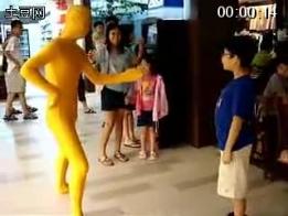真人玩具（流畅） 美女穿黄色莱卡衣站在店门口扮成玩具，让人摆弄姿势。