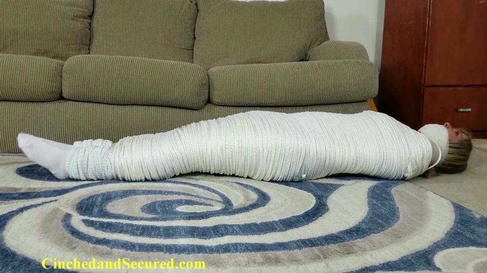 Dakkota Grey Mummified in Rope <span style='color:#b0b0b0;'>[隐藏文字，购买后可见]</span><br>Dakkota's husband is not happy about being stood up for their weekly date night, especially when he was left waiting at home for her while she was out drinking with her friends.  He's so disgusted at his treatment that he decides that from now on, she's going to stay exactly where he wants her, and what better way than with a little rope?  If a little ropes is good, a lot of rope is better, and that's exactly what she gets! The sexy blonde MILF finds herself mummified from her shoulders down to her sexy sock-clad feet in 2,600 feet of rope!  You read that right:  DAKKOTA IS MUMMIFIED IN 2,600 FEET OF ROPE!  Unable to move at all, the gagged girl does her best to wriggle herself free, but it's literally impossible.  In fact, the cocoon is so tight and so heavy, she can barely move!  Her husband is now confident that she won't be stepping out on him anymore, but the bad news is that untying her is far too much trouble to deal with, so he's going to leave her just as she is!  From now on, she'll be going nowhere!