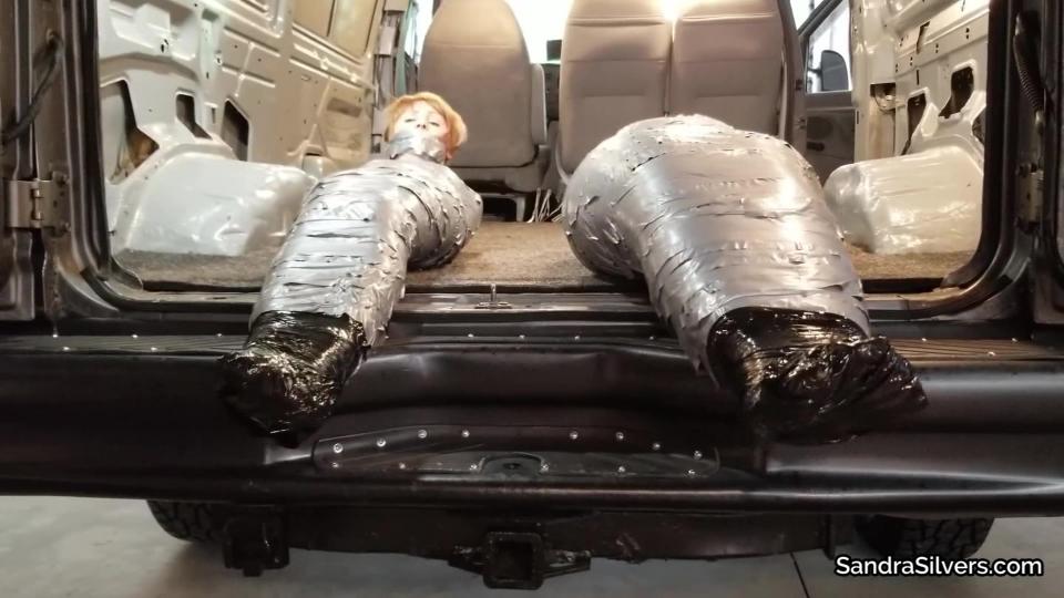 Sandra SIlvers, Vivienne Velvet <span style='color:#b0b0b0;'>[隐藏文字，购买后可见]</span><br>Extreme Encasement Van Ride for Pantyhose-d Pair – Sealed in See Through and Black Plastic Pallet Wrap, then Duct Tape – All On Screen!<br>A Custom Video!<br>Body stockings - barely clothing in such sheer silky nude nylon - low cut over cleavage, the deep scoop neck of the pantyhose grazing nipples of each, ball gags of pink and purple pulled tight between their lips and cold steel collars holding them fast as they stand to attention. Their range of movement limited not only by the steel pipes holding them to the wall, but wraps of gray duct tape at wrists, ankles and knees. Tottering on high heels they are secured, though one false move on a stiletto would leave them hanging… The two slaves had been bickering and their Master had enough. He planned to keep them quiet for a while, let them think on their misbehavior, and then he has a surprise in store for them both...<br>With a plentiful supply of the silver tape, he wraps further coils around their legs, waists, arms; and seals the drool-inducing, jaw spreading ballgags in place with tape right around their heads. Not more than an ‘Mmmph’ will escape those pretty pouts now! Next a full ankle to neck covering of see-through plastic packaging wrap squashes their tremendous tits against their rib cage, a distracting sight for sure, if he’s to continue with his day he’ll need to add another element to prevent the delightful damsels from diverting his attention… Just the thing, an industrial role of black plastic pallet wrap and to top it off a full encasement of duct tape completes the preparation of the pair of pretty parcels! Now into the van the hulking harasser hefts the hobbled hotties, heels waving, their layers elicit a squeak as they attempt to struggle, off with their shoes we see their exposed toes wiggle before they too get generous wrappings of film and tape.<br>He’s done with them. Time to transport them to their next house of servitude…