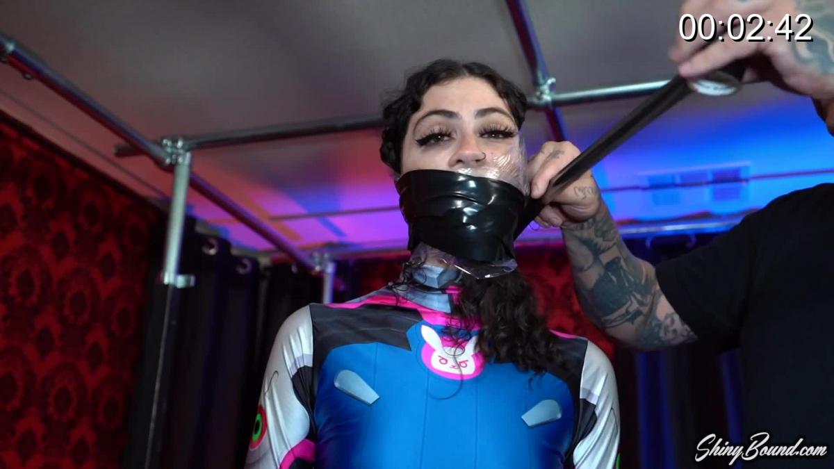 DVa Shrink Wrapped Sexy Lydia Black in her silky DVa catsuit gets her mouth stuffed with satin panties and then wrapped and taped over. Her hands are wrapped, and then she is then tightly wrapped and taped to a pole and left to try and struggle! Spoiler.. She is so tightly fixed to the pole that she can't move an inch.. Just moan and blink..
