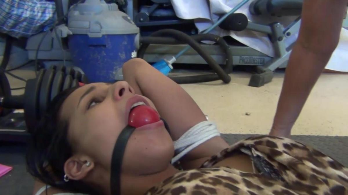 UNENTHUSIASTIC BONDAGE TOY MP4 I come home to find my husband in the garage with a young hot Latina girl bound up. I'm about to flip out on him when he tells me Mandy Candy is a present for me. How thoughtful!!! Wow - this bound beauty is hot as hell. I carress her pretty little face and grope her sexy body feeling her small tits. I'm not into women she protests!! Well babydoll isn't that the point of bondage - you have no choice. She continues to balk so I shove a huge red ballgag deeply into her mouth shutting her up. I just love young hot brown skinned girls. Her arms are bound up over her head and I add another rope cramming her elbows tightly together on top of her head. Mandy begins to cry beneath her gag when I yank the rope. Isn't this fun - just me and you here all night by ourselves. I lay the bimbo down and feel her cute small tits and her hot hispanic pussy. The poor helpless bondage toy has no choice but to submit to my fondling. I staddle her and tell her the plans for later kissing her ball gagged mouth. I lay her body down and tell her to relax - after all we have all night to get your ready to eat some pussy ...<br><br>