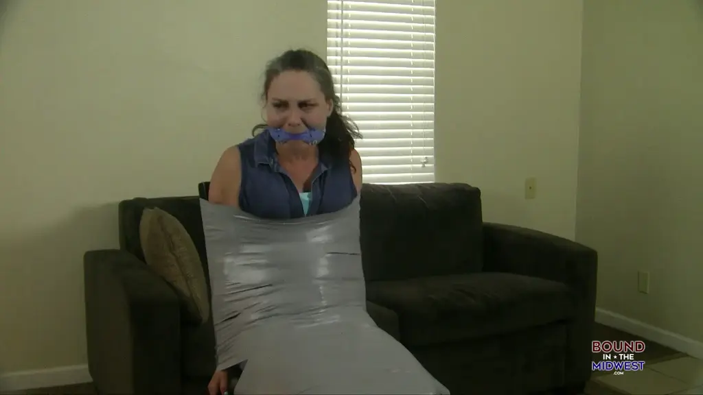 Genevieve Bound And Gagged In Jeans Gen is bound and gagged with rope and a bandana gag. he hops around the apt trying to get to the locked doors and window and trying to get free. When she tries to escapes she was recaptured and is mummified to a chair and he adds a lot of tape around her mouth and a blindfold and watches her struggle. 
