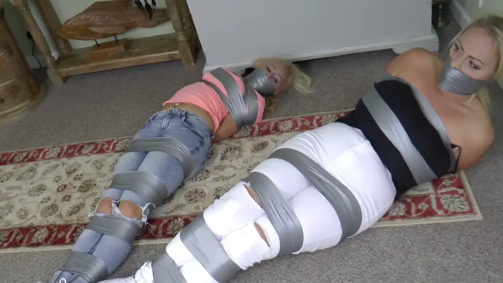 Terrie &amp; Charley in: Enough! Gag Them Both &amp; Tape Them Thoroughly. They Get Loose, It's original title:<br><br>Terrie & Charley in: Enough! Gag Them Both & Tape Them Thoroughly. They Get Loose, It's Game Over For Us!<br><br>Ultra-buxom - all-natural jumbo boobies by the way - Charley and busty blonde sexpot Terrie have big mouths. They are what is referred to by the shady criminals they hunt, 'screamers'. They need to be quieted, quickly, or they are liable to attract attention. The crooks who will soon have them do NOT want that to happen. Yes, these two lovelies need to be gagged exceptionally ruthlessly, with mouths jam-packed full of cloth and sealed up by wall after wall of tight tape.<br><br>The gorgeous blonde girl detectives are sneaking around the notorious Cyclops House (an old place outside the City walls, long associated with dark dealings, etceteraaa etceteraaa. The girls believe they have this covered and that they can extract some vital clues quickly and quietly and turn them over to HQ. But HQ didn't get the memo and won't for a few hours yet. If they HAD, the girls would have been warned to stay well clear, for none other than the Galaxy Gang (so named for the uh, vast array of planet-like smash and grab hotspots they, um, target yeah) are holed up here presently, and these pricks play very rough indeed.<br><br>Splitting up, the busty (did we mention they have large tits?) girls move quickly, snooping around in the usual very watchable fashion. One by one they are jumped, handgagged and bundled off kicking and squealing to a room at the back of the house. Here the feisty blondes are ordered, by Brian 'Pliskin' Adamaski, Henchman, to kneel and are next wrist-bound (Charley while bent over an old chest, for no real reason other than that it looks quite compelling) with sticky grey tape designed to hold fast just this sort of meddling bitch. Now, the restrained duo start mouthing off and the orders are to keep them gagged - for this very reason - extra hard. Grubby socks are shoved into their mouths to keep them quiet as a load of tape is bound with mondo-tightness about their lower faces.<br><br>These skin tight warp gags look amazing and the girls are utterly bedevilled by them while they try to fend him off as they are further tape trussed. Then they are left to wriggle and writhe on the deck, and gag talking incredibly. Lots of rolling about and straining to break these impossible bonds. The girls are held particularly fast and going nowhere at the same pace.<br><br>Later, and the pair are surely no closer to escaping. Adamski struts back in and wrestles off their shoes, giving us all an eyeful of some sexy bare feet. The girls are not impressed and the smugass bad guy heads off, having added an extra layer of vulnerability to the bound and silenced detective girls. Barefoot and exposed, and they DO not like that. But we do. And this next heady sequence incudes attempts to open draws with toes, to genuinely communicate instructions and based on those instructions, and a whole host of other gagged up goodness. These two stunners can really act too. They hold their own here at Borderland Bound with many of our brightest and best. We sure are glad that order to gag these two so massively came down; they look verrrry cute like that. The crooks have attended to these two meddlers all too well and it seems escape will not be coming just yet. Rest well tonight, girls. You'll need your energy to tell your tale when HQ eventually send out agents on the hunt. Of course, by then the gang will be long gone. Mission: FAILED! Mwuahahahahahaha.