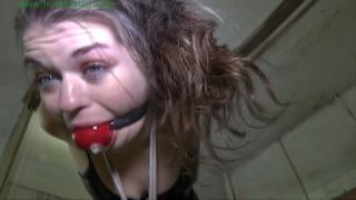 Slutty coed strappado bound orgasms Slutty coed Anastasia is dragged into the lair tightly bound and gagged. A big red ball gag is jammed between her teeth and her arms are fused together behind her back in ropes. Her elbows kiss with ropes biting deep into her biceps with more ropes slicing deep into her wrists, welding her forearms together into a single unit. The Hunter attaches her bound wrists to a chain hanging down from an overhead pulley and then grabs his remote. Anastasia can hear the whirl of the electic motor and feels the tug on her wrists as they are slowly raised high in the air behind her back. She stomps her feet and bitches through her gag as her arms are twisted up into a cruel strappado. The Hunter leaves her alone to struggle helplessly in the ropes. He returns with a spreader bar and ties her slender ankles to the bar, spreading her legs wide apart and causing her short plaid skirt to ride up her ass. Another rope it tied around her neck then run down to the center of the spreader bar and tied off. Anastasia's head is pulled down and her arms are pulled up as he ties her neck to the spreader bar. The Hunter grabs a wand vibrator and goes behind her. She jumps as the vibrator is turned on and placed against her pussy. Anastasia moans and sobs through her gag as her pussy grows wet as it is stimulated and vibed by the vibrator. She struggles to close her legs and pulls at the ropes as she feels her orgasm build up inside her. She screams through her gag as she cums hard as she pulls desperately at the ropes. The Hunter pulls the vibrartor away and leave her hanging limply in the strappado. Anastasia legs are like rubber and she feel that she would collapse to the floor if she weren't strung up by the ropes. She moans and sobs through her gag begging for more stimulation and bondage.