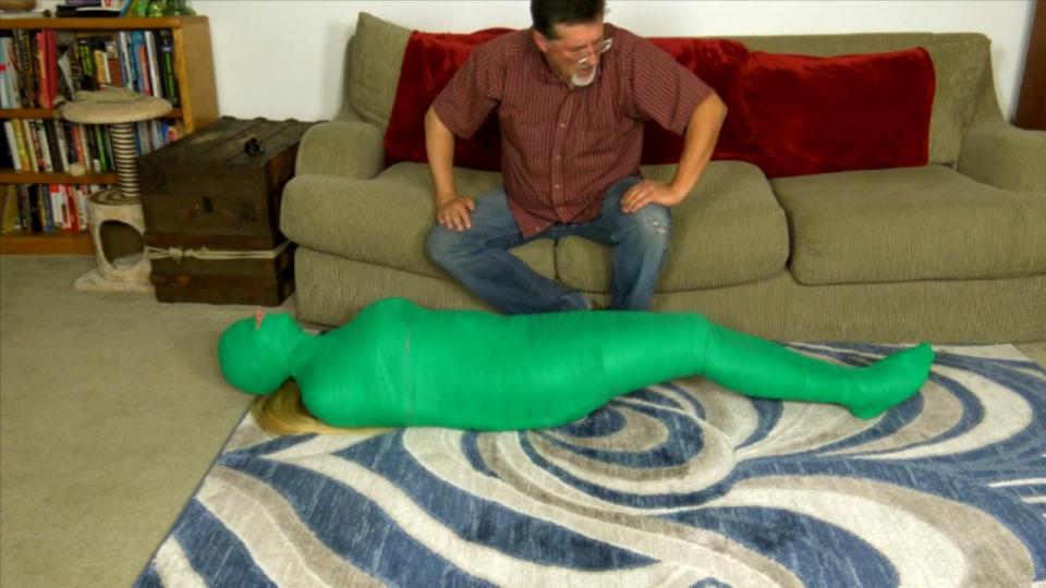 Christina's First Mummy (MP4 Format) 克里斯蒂娜·斯凯一直在努力工作！她只想去一个阳光明媚的目的地度一个愉快的长假，但现在旅行太贵了，她实在付不起。幸运的是，我知道一种飞行方式，只需花费一小部分的费用！对克里斯蒂娜来说不幸的是，你必须作为货物飞行！从头到脚裹着绿色的医用绷带，这个被堵住了嘴的女人挣扎着，咕哝着她的不满，她扭动着想要松开绷带。绷带突出了她丰满身材的每一个曲线，她的长腿，她可爱的脚，从头巾顶部露出的金色长马尾是锦上添花！由于只有眼睛和鼻子露在外面，她除了喵喵叫和咕噜咕噜地插嘴之外，对自己的困境无能为力。当我回来的时候，她尽她最大的努力请求释放，但是我知道她有多需要这次旅行，所以我没有。知道她有多喜欢惊喜，我决定最好她不知道自己要去哪里，所以我把她的头完全包起来，直到只露出鼻子和马尾辫！现在她被关进了她那无眼的监狱，她开始绝望了。我把她推到地板上，她只能感觉到我的手放在她身上，把她翻过来，确保包装没有松动。在飞机起飞前我们还有几个小时，所以我会很高兴看到她性感的身体在绷带下蠕动！Christina Skye has been working so hard!  She'd like nothing more than a nice long vacation to a sunny destination, but traveling is so expensive these days she just can't afford it.  Fortunately, I know a way to fly at a fraction of the cost!  Unfortunately for Christina, you have to fly as cargo!  Wrapped from head to toe in tight green medical bandage, the gagged woman struggles and grunts her displeasure as she wiggles about hoping to loosen the wrappings.  The bandages highlight every curve of her buxom figure, her long legs, her cute feet, and the long blonde ponytail peeking out of the top of the head wrappings is the icing on the cake! With only her eyes and nose exposed, she can't do much about her predicament other than mewl and grunt into her gag.  When I return, she does her best to beg to be released, but I know how much she needs this trip, so I'm not having it.  Knowing how much she loves surprises, I decide it would be best if she did not know where she was headed, so I completely wrap her head until only her nose and ponytail are exposed!  Now sealed into her sightless constricting prison, she begins to get desperate.  She can only feel my hands over her body as I move her to the floor, rolling her over to make sure none of the wrappings have come loose. We have a few hours before the flight leaves, so I'll just enjoy watching her sexy body squirming under all those bandages!<span style='color:#b0b0b0;'>[隐藏文字，购买后可见]</span>