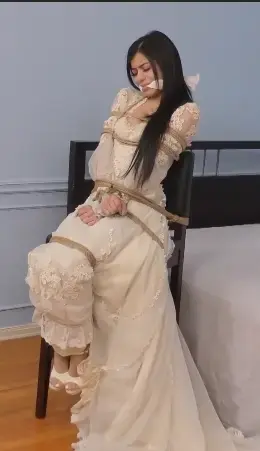 Bride-Napped! - Part Three - Savannah Sixx 随着幻想的继续，蒙面闯入者终于在活动大厅最后面的房间找到了准新娘萨凡纳·西克斯。这位黑发美女第一次见到他时吓了一跳，但她立刻（错误地）相信他是一家公司的员工，这家公司在婚礼前为新娘招揽新娘并带她们参加一个大型聚会。那个思维敏捷的暴徒并没有纠正她，他利用她的不知情的合作为自己谋利。当他告诉她她必须被捆绑和劈开（在屏幕上显示）时，她也跟着玩，他把她引到他的藏身处。在他的藏身处，毫无防备的萨凡娜，仍然穿着长袍，安全地绑在凳子上。她很高兴地为狡猾的绑架者制作了一个她认为是伪造的赎金视频，然后绑架者劈开了无辜的人质，她在表演中给了一个少女，让聚会的人流连。萨凡娜独自一人，但她开始怀疑有什么不对劲时，她保持束缚和塞住了这么久。这个戴面具的恶棍最终回来了，并向他美丽的囚犯展示了他的诡计。萨凡娜然后真的挣扎与她的债券，但她知道她完全在他的怜悯！As this fantasy continues, the masked intruder finally locates bride-to-be Savannah Sixx in the backmost room of the event hall. The brunette beauty is startled when she first sees him, but she immediately (and mistakenly) believes that he's an employee of one of those companies that nabs brides and takes them to a big party before the wedding. The quick-thinking thug doesn't correct her, and he uses her unwitting cooperation to his advantage. She plays along as he tells her she must be bound and cleavegagged (shown on-screen) and he spirits her to his hideout. At his hideaway, the unsuspecting Savannah, still in her gown, is securely tied to a stool. She gladly makes what she thinks is a bogus ransom video for her sly captor, then he cleavegags his innocent hostage and she gives a damsel-in- performance for the partygoers to stream. Savannah is left alone, but she begins to suspect something is amiss when she's kept bound and gagged for so long. The masked villain ultimately returns and reveals the subterfuge to his gorgeous prisoner. Savannah then genuinely struggles against her bonds, but she knows she's completely at his mercy!<span style='color:#b0b0b0;'>[隐藏文字，购买后可见]</span>