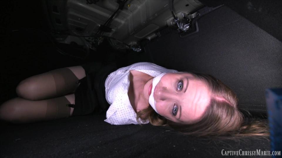 Taken &amp; Tied In The Trunk! HD MP4 克丽茜正要离开工作，戴上口红，这时一个男人从后面出来，用一块布捂住她的嘴和鼻子。他把她击倒带走了。过了一会儿，克丽丝醒来发现自己身处一个黑暗的地方。她试图移动，却发现自己的胳膊和腿被绑得很紧！然后她发现自己在一辆汽车的后备箱里！她试图呼救，却发现自己也被堵住了！在黑暗中挣扎了一段时间后，一个人走过来打开了后备箱。他让她跳到车库的椅子上，然后把她绑在椅子上。然后他把她的嘴移开，结果用一条更大的内裤塞进她的嘴里，把她的嘴塞得比以前更紧！她的腿被绑在椅子的腿上，这样可以清楚地看到裙子，露出吊袜带上的内裤。她的胳膊肘被更多的绳子绑着，然后就剩下她一个人了。当那个男人不在的时候，她拼命挣扎着逃跑，最后她把椅子挪到车库门前，试图制造噪音，希望外面的人能听到。但他回来后当场抓住了她！为了惩罚她，他加了一根颈绳，把她脱光上身，以示羞辱！然后他又离开了她，这次怕挣扎得太厉害，否则她可能会[不可描述]！克丽丝无可奈何地进来了，担心那个男人下一步打算对她做什么！Chrissy is about to leave for work and putting on her lipstick when a man comes up from behind and grabs her with a cloth over her mouth and nose. He knocks her out and carries her away.  Sometime later, Chrissy wakes up to find herself in a dark place. She tries to move only to find that her arms and legs are tied up tight!She then figures out that she is in the trunk of a car! She tries to call for help only to find she is also gagged! After struggling in the dark for sometime, a man come and opens the trunk. He makes her hop over to a chair in the garage and he proceeds to tie her down to it. Then he removes her gag, only to stuff her mouth with an even bigger pair of panties and gags her even tighter than before! Her legs are tied spread to the legs of the chair giving a clear view up her skirt exposing her panties at garters. Her elbows are bound with even more rope and then she is left alone. While the man is away she struggles desperately to escape, eventually working the chair over to the garage door in an attempt to make noise hoping someone outside will hear. But then he returns and catches her in the act! To punish her he adds a neck rope and strips her topless for added humiliation! He then leaves her again, this time afraid to struggle too hard or else she might choke! Chrissy helplessly mmpphhss in , worrying about what the man plans to do to her next!<span style='color:#b0b0b0;'>[隐藏文字，购买后可见]</span>