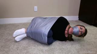 Chrissy Ball Tied Mummification  I've been dared to do an escape challenge that is most certainly unbeatable, but in good spirits I decide to take it on anyway, how bad can it really be? I was told I could stay in my skinny jeans, tight sweater and white ankle socks this time to protect my skin, which is a rare treat as it's usually insisted that I'm mummified in the nude! Tape is wrapped around my ankles securing them together, then my thighs are taped up to my torso. Next he taped my wrists together behind my back before starting to tape my calves up against my thighs, then starts wrapping the tape all the way around my body, up and down several times until I'm bound into a tight ball from ankles to shoulders. (Taping is off screen but partly shown in the behind the scenes version of this clip-see below) <br><br>At this point I can already tell that this is even tougher than I had imagined it would be! I can hardly move at all and struggle to keep my balance. The scene starts as Master Matt informs that I'm going to be gagged with a dirty pair of socks from my hamper, and I shake my head no and refuse to open my mouth, but in the end I know there is no way around it and I submit, opening my mouth wide for him to pack two whole socks into until my mouth is held open from being stuffed so darn full! He wraps the duct tape around my head several times as I mmpphh and grunt, in complete disbelief of how tight he gagging me for just an escape challenge! He goes on to tell me that he is giving my only 10 minutes to escape from my predicament, or else he is going to leave me alone to endure an even worse one!<br><br>He lays me on my side and I start to struggle as hard as I can, pulling on the tape, trying with all my might to unbend my legs, but just as I had dreaded the tape doesn't budge at all! I try to move and roll around only to realize I am quite immobilized in this ball tied, I can barely squirm an inch! Master Matt steps in and helps me turn onto my back, thinking that perhaps it will help me make some more progress, but I just continue to frantically gag talk to him that he has gotten me into an impossible challenege and there is no way I'll be able to escape! He just keeps playing his game and tells me it's a damn shame he can't understand a word I'm saying! I mmmpphh as loudly and angrily as possible towards him as he teases me in my helplessness! He tickles my socked feet to show off that I can't even do anything about it! I just laugh and scream through my gag. He tells me he is going to add to the challenge that if I don't escape he is going to remove my socks and tickle my bare feet. He knows how much I hate tickling and this really pisses me off, I was almost ready to give up but now I'm determined to fight and struggle until the very end! Unfortunately by this point my time is running short and I haven't got a plan or idea of how to get out of this mess. Will I be able to escape? I think it's more likely I'll be stuck in this inescapable mummification, tickle , then left to suffer and struggle for an undisclosed amount of time! I hope I think of something quick!