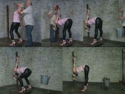 Her poor body was twisted into a leg spread strappado tied to a post Bleach blond Lauri Adverb stands on a platform looking at a post in front of her. Her lean legs are spread and tied off to rings mounted on the platform. Her arms are fused together behind her back with ropes crushing her elbows completely together. She bitches and complains cursing at the Hunter in defiance. He walks in and pulls her head back by her hair and stuffs a pair of socks into her mouth. He then wraps vet wrap around her head sealing the gag in tight and stifling her defiant curses. Lauri pulls at the helplessly at the ropes. He grabs more rope off the floor and pulls her arms up high behind her back her to bend over. He then ties her wrists to the top of the post with Lauri head down between her legs. Ropes are then wrapped around her arms fusing her arms to the post. He then ties a cruelly tight crotch rope between her legs and ties the end of the crotch rope to another rope running up behind her to an overhead pulley. A bucket is tied to the end of that rope and barbell weights are added to the bucket pulling the crotch rope deep into her pussy and ass and her to keep her ass high in the air. Lauri is still a bit defiant trying to flex her knees and pull down on the heavy bucket. But the heavy weight proves to be too painful as the rope bites deep into her crotch and she gives up. He leaves the defiant wench cruelly bound to the post barely able to move to break her spirit.<br><br><span style='color:#b0b0b0;'>[隐藏文字，购买后可见]</span>