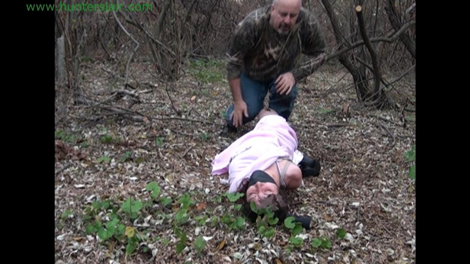 The prom queen thought she escaped into the woods Kali fought off the Hunter and escaped into the woods in her pink prom gown, gloves and heels. She picked her way through the trees hoping that she has eluded her. Unfortunately her arms were useless to her bound cruelly tight behind her back with her elbows welded tightly together. The satin fabric of her shoulder length satin gloves did little to protect her arms and wrists from the tight biting ropes. She was exhausted as she stumbled through the woods. Kali was completely lost and confused on what way to go. She didn't see the tree root that caught her shoe as she fell onto the ground. She cried in frustration and pain and sat on the ground for a few moments to catch her breath. But she knew she couldn't rest for long, she had to find help and or at least get her arms free from the cruel ropes. The more she walked the more confused and desperate she became. She felt like she was walking in circles. She didn't even hear him coming as the Hunter jumped out from behind a tree. Kali turned on her heels and tried to run. But in her exhausted state and the uneven ground she stumbled and fell. He was on top of her in a second and she tried to kick and fight him off with her stilettos. But he easily warded off her kicks and restrained her with an arm around her throat and a large bandana into her mouth. Kali cried and moaned as he then wrapped black vet wrap around her head sealing her gag in tight. He pushed her to the ground and stood over her. Kali looked up pleading with her eyes as he drops more rope on her. He then flipped her over onto her belly and hogtied her so that her stiletto heels were pulled up to her gloved hands. He got up and walked away leaving her completely helpless hogtied on the forest floor. He told her he would be back in an hour or so and then they would be going for a little ride. Kali watched as he disappeared into the undergrowth. She pulled helplessly at the ropes rolling around in the dirt and leaves. There would be no escape this time all hope was lost.<br><span style='color:#b0b0b0;'>[隐藏文字，购买后可见]</span>