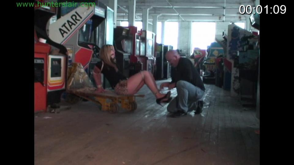 Bound hostage escapes her k'napper Sexy secretary Destiny has been and is pushed along in an old warehouse by the thug. She is tightly bound and gagged with her arms hanging uselessly behind her back bound at the wrists and elbows. Her knees are tied together to keep her from running away. Her high heels scrape on the hard wooden floors as he pushes and drags her along. He shoves her down onto an old steel cart and ties her ankles together. Destiny struggles with him but in the end she is overpowered and the ankles are tightly tied together. He leaves her there telling her in a threatening tone that he will return and she had better no try to escape. But as soon as he is gone Destiny begins starts to plot how to get away. She tries to undo the knots holding her wrists tightly together but the knots are too tightly tied so she struggles to reach her bound ankles but once again the ropes are too brutally tight and she can't get to them. She realizes that her only hope is to hop so she struggles to her feet. She then starts to hop in her high heels looking for something to help her cut her bonds. But there is nothing sharp enough to be of help. She just about give up hope and is exhausted from hopping when she finds an old office chair with wheels. She falls into the chair exhausted and pushes it along with her bound feet. She doesn't know where she is going but needs to find help. She finds and open window and screams through her tightly strapped ball gag out the window for help. But her screams are mutted by the gag and no one can hear her. So she falls back into the chair to look for a way out. Will she escape or will the k'napper return and punish her for her attempt? <br><br><span style='color:#b0b0b0;'>[隐藏文字，购买后可见]</span>