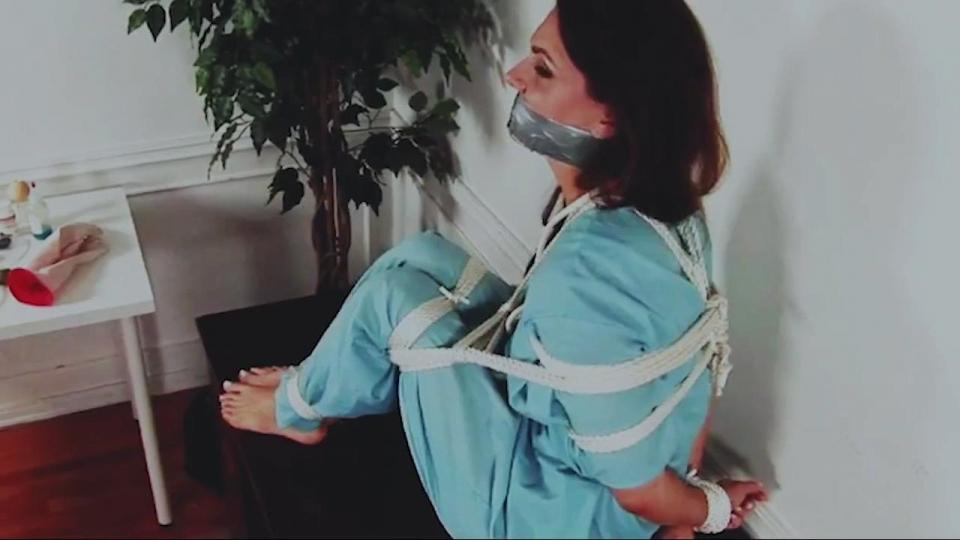Dr Holly Manning is Tied Up With a Tight Wraparound Gag to Keep Her Beautiful Lips Silent! 霍莉·曼宁博士是一名正直的医生，所以当她发现一位同事通过非法赚钱时，她知道她有责任举报他。 但是那个绝望的男人拒绝安静地走;相反，他把这位好医生绑了起来，她的鞋子被剥夺了，赤脚在她的桌子边缘，直到另一根绳子把她的腿拉到她的躯干附近，管道胶带增加了她的呕吐!<br>购买链接<span style='color:#b0b0b0;'>[隐藏文字，购买后可见]</span>