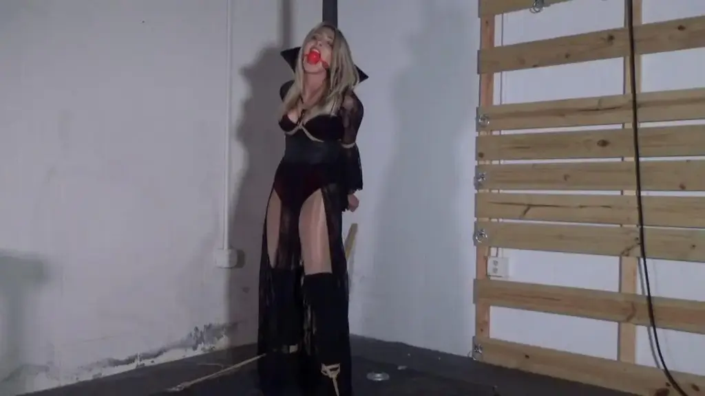 Rosie Vengeful Vampire Pole Tied HD Lovely blonde Rosie dresses up for Halloween in a sexy vampire costume with knee high boots and pantyhose. Since she wants to look the part, perhaps it's a good idea she plays the role. One that involves a dangerous creature of the night captured and punished. She's bound to a pole with ropes tied tight around her chest and arms and ankles spread. Rosie tries talking but a large ballgag is put in her mouth so somewhat quiet her down. This is not what she was planning for a fun halloween photo shoot. With the assistance of our hunchback friend, her one leg is tied and pulled up to make things more interesting. Rosie can't help but scream and beg doing lots of gag talk, demanding to be untied and set free. She gets really mad, cussing but we know how to put bratty girls in their place. A few cracks of the crop on that booty of hers will keep her in check. All that struggling will do her no good except tire her out. <br><span style='color:#b0b0b0;'>[隐藏文字，购买后可见]</span>