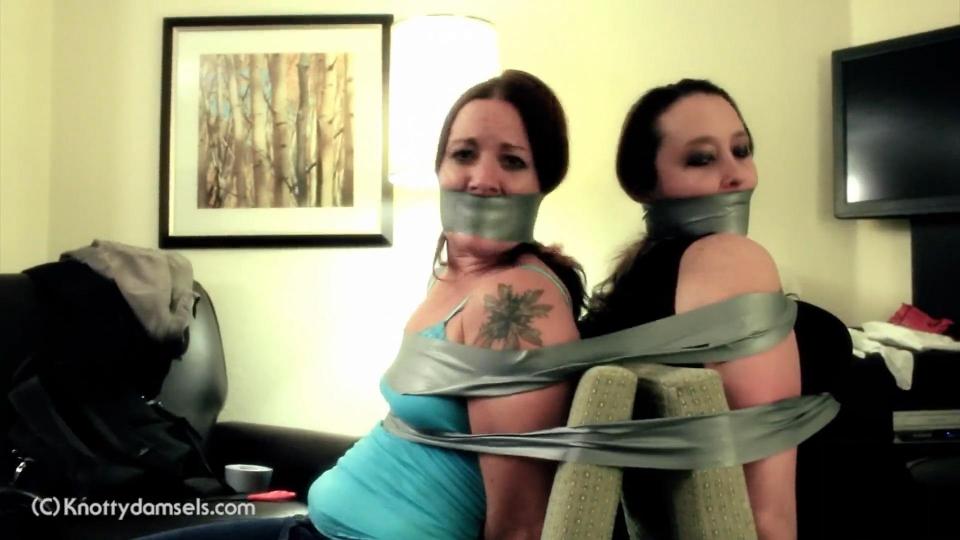 Fayth On Fire and Nova Starr: Taped Back To Back Fayth On Fire and, in her only bondage shoot, Nova Starr, are both captured and taped to a chair back to back, gagged with tape wrapped around their heads. Fayth, the veteran, has been through this situation before and tries to get Nova, who is inexperienced, to cooperate through communication as best she can. But, when you can only let out "mmpphhs," Nova has no clue what Fayth is saying. Soon, their captor appears and taunts the pair by throwing a pair of scissors near Fayth, knowing the two have to work together to get free. Fayth, ever the resourceful one, decides to take matters into her own hands.<br><br><span style='color:#b0b0b0;'>[隐藏文字，购买后可见]</span>