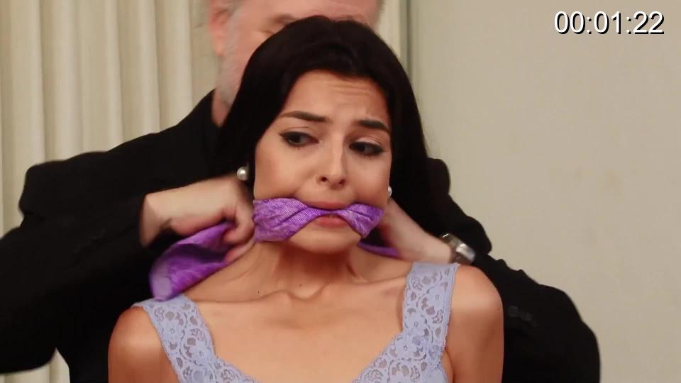Going For The Phone - Secretary Phoebe Queen is Bound and Gagged Sweet secretary Phoebe is completely alone in the office when a business-suited gentleman stops in. Only he's no gentleman, so he Phoebe into ropes and ties a cleave gag between her pretty lips. He sets Phoebe's phone out of reach and then he starts searching the office for something valuable. Phoebe struggles and squirms her way across the floor toward her phone... but her captor notices at the last moment and moves the phone away. Once he finds his loot, he drags Phoebe onto the chair and ties her down before leaving her alone to mmph and squirm. Intrepid Phoebe once again tries to reach the phone, this time with her feet; she wriggles so hard her shoes come free at the ankle, but her efforts to get her phone are thwarted once again. -- Video verite'. -- Secretary, rigging, onscreen tying, burglary, bad guy, topless, mini skirt, miniskirt, tank top, old-fashioned shiny stockings, red shoes, strappy heels, losing shoes, stockinged feet, bandanna gag, cleave gag, cleavegagged. Thief: Jon Woods. <span style='color:#b0b0b0;'>[隐藏文字，购买后可见]</span>