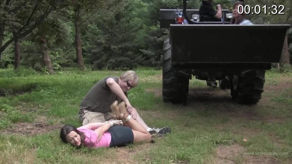 Christina &amp; Serene - Outdoor Bondage Delivery The clip opens with me and Christina Carter being driven up a long dirt road in the back of a front loader. Our wrists have been tied behind us and there's no way we can jump out of the thing with it moving. The creepy driver just keeps going further and further into the secluded area. He finally stops near a picnic table where his partner is waiting, we see him as we round the corner.<br><br>The man lowers the bucket and his partner grabs me pulling me out and me to the ground. He gives his partner and thumbs up and he raises the bucket again to keep Christina trapped inside, to watch him tie me but unable to help. I wiggle and squirm on the dirty ground as he ties my ankles tightly together. Christina yells out from the bucket for him to stop, but he isn't ready to bother with her yet.<br><br>Once my ankle are bound, the man sits me up and stuffs my mouth with a big wad of cloth and wraps microfoam around my head so tightly I can feel my cheeks puffing out over the top of the tape. He lays me back down on the ground and my elbows together, tying them in place. I try to kick at him, my legs smeared with mud from the ground.<br><br>The man signals his buddy to lower the bucket and he pulls Christina out. He her to kneel beside me. She begs him to let her go and I yell at him through the gag. I try to slide closer to her hoping she can untie my arms. She loses her shoes trying to fight him off as he ties her ankles together as well. She slides further away and I try to kick him but he stands up my feet missing him by inches.<br><br>Christina's elbows are next and they get lashed together like mine, thrusting her breasts forward and straining the button in front. She tells me to kick him again and I slide forward and rear back with both feet. He looks over at me and threatens to hurt her if I do it. I put my feet down, believing every word he says. He finishes the knot and stuffs some cloth in her mouth as well. He winds the microfoam tape around her head sealing the cloth in side and turning her screams to whimpers and moans.<br><br>Christina gets up on her knees and tries to “run” away, but he reaches out and grabs her pulling her back to the ground. He uses another rope to hogtie her ankles up to her elbows making the escape attempt a little more difficult. It's my turn next. He pushes me to the ground and hogties me next to her. She arches back and pulls against the ropes, her legs also smeared with the clay on the ground. He leaves us alone to go get a drink and we roll around on the ground, struggling and yelling, but it doesn't do any good. The ropes just seem to get tighter the more we pull on them. <span style='color:#b0b0b0;'>[隐藏文字，购买后可见]</span>