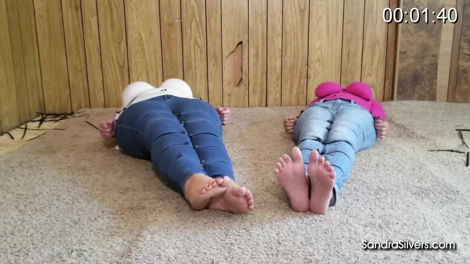 2866 Sandra Silvers, Lisa Harlotte and Amanda Foxx Strict Sweater Bondage for MILFs Amanda and Sandra – Part Two - Ziptied for a Foot Feast from Lisa!<br><br>Amanda and Sandra lay together, their limbs locked into a straight side by side position by severe zip tie bondage, and though the women are but mere inches apart they are both unable to reach out for comfort from their bound companion. They have been laid out and prepared by a bearded, broad shouldered brute (see their bondage beginning here) for his lady, Lisa, who lusts after ladies feet, and these two MILFs are quite the barefoot treat… Curvy, silver haired Sandra and equally busty blonde Amanda long to feel freedom from the cruel teeth of the plastic cinches biting through their tight blue jeans and knitted sweaters. Woolen stitches imprinting on their skin, as the zipties dig in to their flesh further with each futile struggle. Even their big toes are restrained by cable ties. Lisa is unrestrained in her foot worship, letting her tongue loose on the MILFs toe gaps and wrinkled soles, she coats their soft bare feet with her saliva till their soles glisten in glorious close up views. Sandra and Amanda’s predicament seems far away as they realize the pleasure sensations sucking at their soles, slipping into subspace. A fantastic foot fetish feast for all!