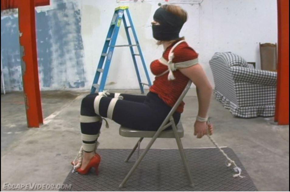 Office Revenge  Lila hasn't been pulling her weight as an administrative assistant. At the company she works at the Human Resources department has their own way of dealing with incompetent workers. let's ust say that Lila finds herself tied up tightly in her skin tight jeans, heels and cleavage revealing top. Check out that fine ass all wrapped up inside her pants. Very nice. Stacy is not gonna take any from this girl. She's had a long day. So she immediately ballgags her and leaves. Lila winds up hopping to try and get out. Stacy grabs her and sits her down. She removes Lila's ballgag and then despite her protests she stuffs Lila's mouth with a rag and then wraps vet wrap around her head.