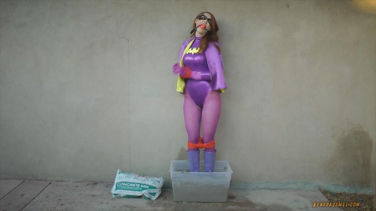 Kendra James Batgirl gets a pair of cement shoes! 蝙蝠女被告知有一个奸诈的特工正在渗透正义联盟。她几乎不知道这是世界上最著名的亚马逊神奇女侠。在她能够弄清楚这一点之前，戴安娜给了年轻的蝙蝠侦探敲她的头盖骨一个强有力的打击。幸运的是，世界上最有权势的女人对头部的打击只是把她打晕了，蝙蝠女醒来时双手被绑，双脚牢牢地粘在水泥里。神奇女侠向紫衣英雄解释说，她厌倦了年轻的英雄们得到所有的赞美，并且在大多数这些所谓的年轻正义小子出生之前，她一直在捍卫世界。随着每一个字的流逝，蝙蝠女脚周围的水泥变硬，巩固了哥谭河底部年轻侦探的神奇女侠计划。<br>内容包括：神奇女侠wonder woman 蝙蝠女侠batgirl 超级英雄hero 女女 内斗 捆绑 堵嘴 口球 调教 恐惧 挣扎<br>Batgirl has been tipped off that there is a treacherous agent infiltrating the Justice League. Little does she know it is the most famous Amazon of the world Wonder Woman. Before she is able to figure this out Diana delivers a powerful blow to the young bat detective's cranium knocking her . Lucky that the blow to the head from the most powerful woman in the world only knocked her out, Batgirl wakes up with her hands bound and her feet firmly stuck in cement. Wonder Woman explains to the purple clad hero that she is tired of the younger heroes getting all the praise and that she has been defending the world before most of these supposed young justice brats where even born. With every passing word the cement around Batgirl's feet harden, cementing Wonder Womans plan of the youthful detective at the bottom of Gotham river.