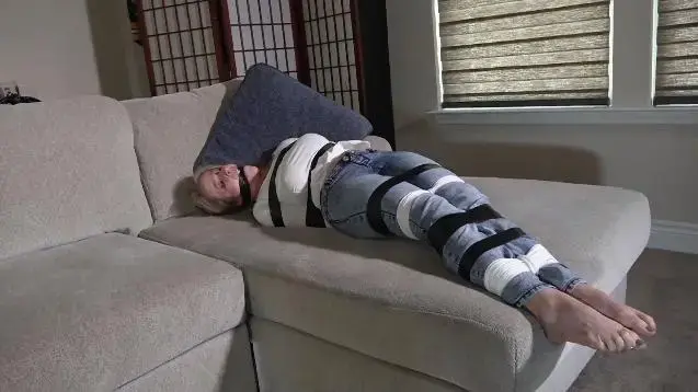 N2210CLAIRE-Hopping around tied up gagged and taped SML Claire is bound and gagged as a man makes her hop onto the sofa. There, he secures her better by taping her up over the ropes that already bind her. He removes the knotted half slip cleave gag and stuffs her mouth. Then he winds black electrical tape around her head and between her teeth to keep her gagged. Claire is then left to struggle bound and gagged. Somehow she gets to her feet and hops to the window hoping to get someone to help her<br><br>