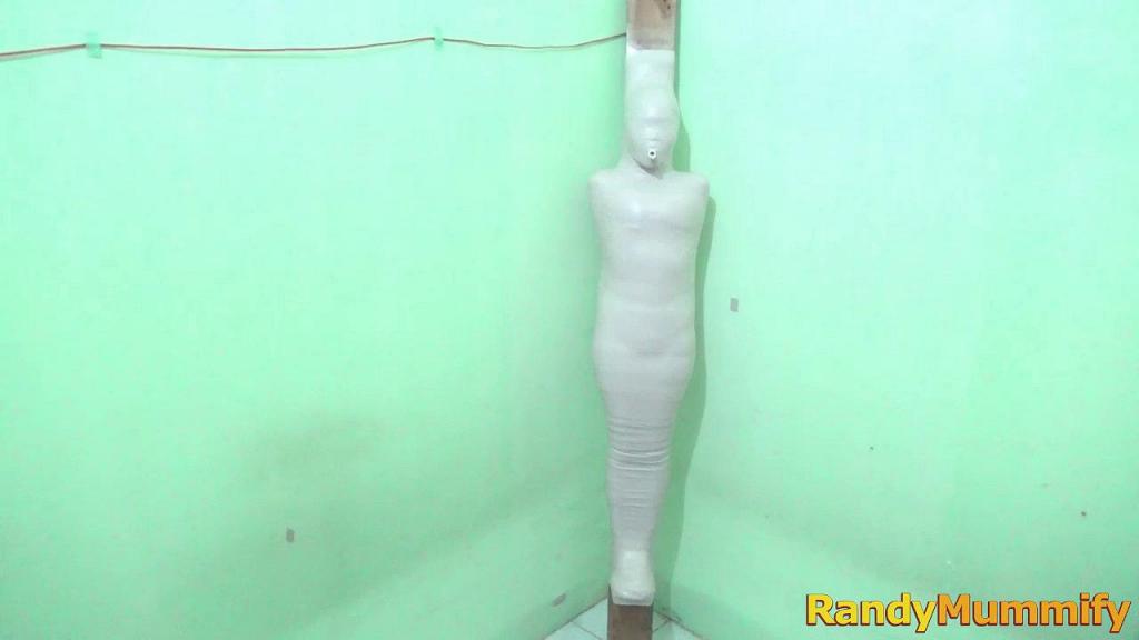 [RM099] A girl in an orange swimsuit is mummified on wood and breathplay A girl with long hair wearing an orange swimsuit is mummified on top of a large stick with a white cloth.<br>This girl was helpless when her nose was closed and only breathed from a small tube