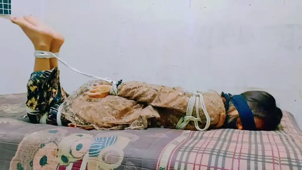 Beautiful girl in traditional kebaya dress tied up in room (ID-BOUND025) Beautiful girl in traditional kebaya dress tied up in a room in a hogtied position