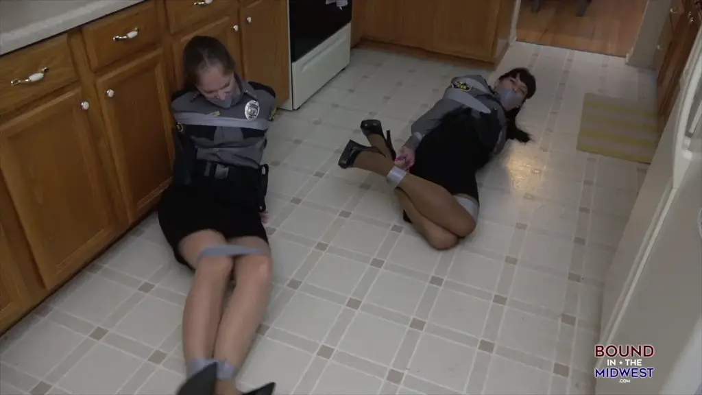 Double Trouble For Security A Police Story An alarm has sounded and Security Officers Rachel Adams and Lilmizzunique have arrived they split up and Rachel go into the living room and kitchen while unique checks the hallways and bedroom. <br><br>Rachel is grabbed and taped up in the kitchen as she struggles Unique finds her and is grabbed and tied up the same way. They take them into the living room and tied up into some chairs and they change to rope and cleave gag. They struggle for a while and then they taken down stairs and are hogtied on the pool table. <br><br> <br><br>Then to get then out of the way they tied up back to back on the floor in the living room.