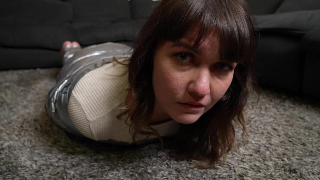 First Time Mummified Rayne is mummified for her first time ever. She struggles against the extra wide duct tape with no hope of escape.