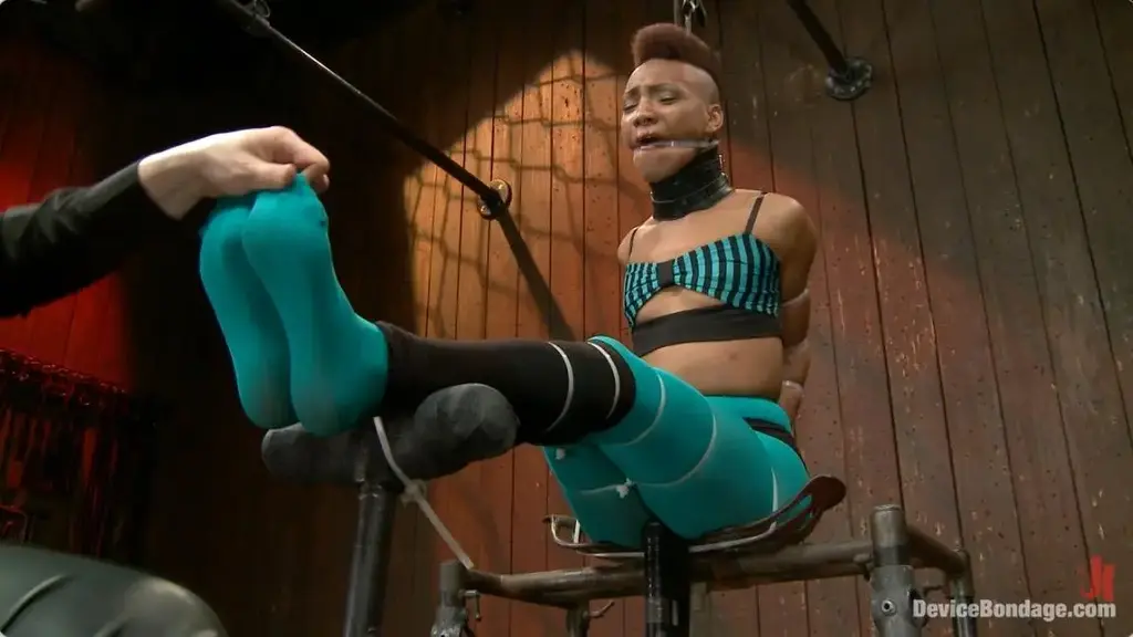 Defiled - Nikki Darling Ebony stunner Nikki Darling is intense. She is an active and performing dancer and has the physique of a sleek panther in its prime. In scene one, she is given a perch. Sitting on an uncomfortable vintage metal tractor seat that is transformed into a mini throne, her whole body is zip tied together. Her elbows touch as vicious and inescapable hard plastic bites into her flesh all the way down to her feet… her lovely tender soles. Claire clips off the last zip tie, taking Nikki’s shoes off and creates a uncomfortable predicament for Nikki that the cunt won’t soon forget involving nipple clamps, wax, the cane, nipple weights, and twine from each of Nikki’s big toes to her nipple clamps. In scene two, the panther is on the prowl. She is positioned in a low crouching doggy in metal and leather, and made to look like a panther ready to strike. The greedy whore cums from pain and Claire obliges her by using the single tail and a really stingy rubber flogger. With her amazing ass displayed in the air, a nice thick cock is rammed to the hilt into her more than willing ass hole. Orgasm after orgasms, she moans and writhes. Finally we test this bitch and push her to the max in endurance flexibility bondage. A cruel forward bend strappado suspension in leather. Claire goes after her feet with the cane, introduces harsh clamps to Nikki’s labia and a nice anal hook to the booty. Orgasms are ripped from this helpless cunt’s body. So hot. So helpless.