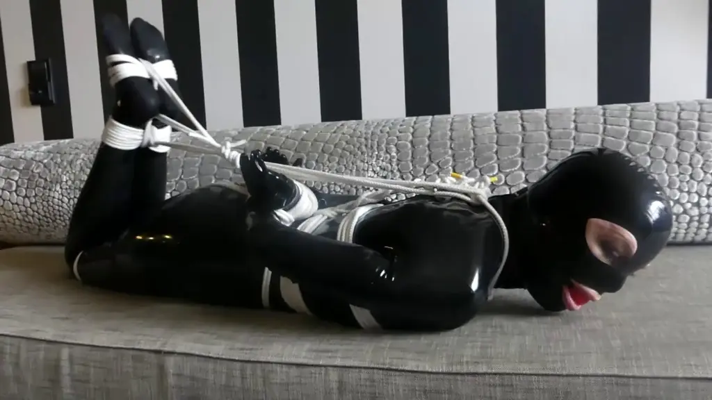 FULL RUBBER ENCLOUSURE BONDAGE 4. HD Meet are favorite rubber girl Mary. Dressed in tight shiny black rubber from head toe and tied tightly with thin white ropes. Fitted with a big red ball gag strapped tightly between her full red lips poor Mary can do nothing but roll her eyes and make squeaky rubber noises and moans while the saliva drips from the tight gag. Here in part 4 we add a few more tight ropes for good measure and tie her in a stringent hogtie to make her a little more uncomfortable as we want those small noises and moans sound a little more desperate.