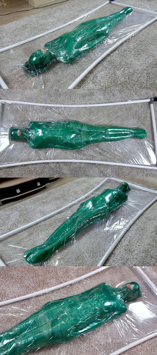Green stretch film in a clear vacuum bed 妹子被用绿色保鲜膜包裹成木乃伊。<br>随后进入透明的真空床内，抽干空气。<br>真空拘束带来的压迫让妹子欲罢不能，在真空床里苦苦挣扎。