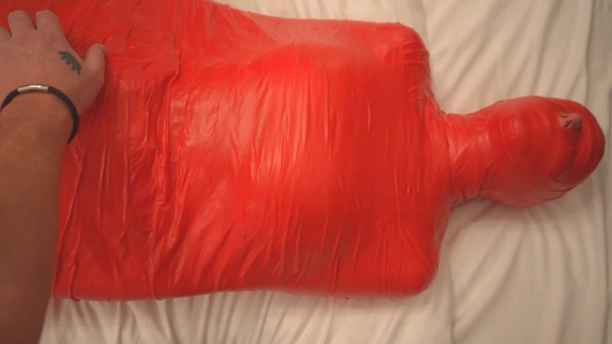 Sirs tape mummified little monster (mp4) My submissive has been very mischievous and naughty recently and a pain in my ass and she knows it. So what do you do when your play partner is being a little monster? You turn her into one. Completely encased in red pvc tape she has no chance of escape. Head to toe and unable to move she is securely mummified with very little wiggle room. Gagged with multiple layers of tape also her crys and muffled and low. I also fasten her to the bed at the head and feet Completely immobilising her. I begin by teasing g her through the tape by tickling her private areas and feet which she really hates. I later turn her into the little monster she is and I draw I a monster face over the tape wrapped head. I leave her to struggle for a while befor cutting a slit near her pussy and tease her with her vibrator. She struggles more in frustration as I prevent her from orgasm which again she is not pleased with. After watching her moan and struggle more I allow her to finish herself off before cutting her free from her tape cucoon