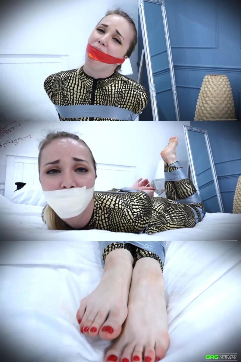Lil Missy UK - Catsuit Burglar Captured After Nap FULL 3 Gag Video HD 花絮1过了一会儿，捕捉米西的人回来了，在她的嘴唇之间放了一个球形花絮，颜色与她裸露脚趾上的清漆相匹配，她沮丧地扭动着脚趾，仍然无法挣脱。试图通过中等大小的插科打诨说话。第1层更吸引人的是，在床上扭动，另一个插科打诨，这一次是一个橙色的海绵球，用红色的窄PVC胶带粘住。我们看到了米西穿着紧身衣的漂亮身材，她继续与身体和腿上的带子缠在一起。第二层房主用可能被释放的可能性来挑逗米西，但却粉碎了她的希望，在她的头上加了几层2英寸的微泡沫胶带，实际上让无助的闯入者沉默了下来，她已经离挣脱束缚越来越近了。她在努力中喘着粗气，最终承认失败，躺在那里一动不动。Gag 1 After a while, Missy's captor returns and places a ball-gag between her lips, the colour matching the varnish on her bare toes, which she wiggles in frustration, still unable to get free. Trying to speak through the medium sized ballgag. Layer 1 More attractive writhing about on the bed follows, as another gag is applied, this time an orange sponge ball held in with red narrow PVC tape. We are treated to views of much of Missy's nice figure in the catsuit, as she continues to fight against the loops of tape around her body and legs. Layer 2 The homeowner teases Missy with the prospect of possible release, but dashes her hopes, for good measure adding a few layers of 2"Microfoam tape around her head, virtually silencing the helpless intruder, who is no nearer escaping her bonds. Breathing heavily from her exertions, she eventually admits defeat, and lies still.