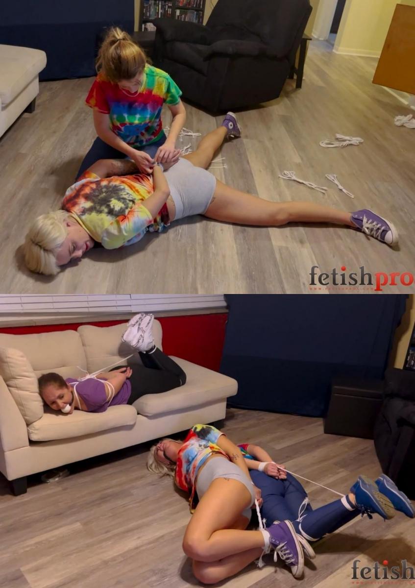 Burglars Bound in Rope And Then Their Victim Gets Hogtied Too 金发碧眼的安迪和黑发碧眼的康斯坦斯闯进一所房子，翻看了所有的东西。他们找到了钱，但也找到了绳子，康斯坦斯决定放纵自己的古怪欲望，把安迪绑在地板上，绑住她的手腕和脚踝，把她绑上一条绑带和一个球塞。然后，房子的主人雷切尔·亚当斯（Rachel Adams）回来看看发生了什么事。当康斯坦斯（Constance）漫谈他们为什么闯入房子时，雷切尔还把她绑成了一条猪扎带，还用球塞住了嘴。根据他们的服装，这两人似乎是“扎染强盗”，但当瑞秋的男人回家时，他决定不报警，而是把瑞秋也绑起来，让三个无助的女人在客厅里挣扎，这样会更有趣！因此，正义的事业被铺平了道路，这样瑞秋就可以在沙发上穿着紧身裤扭动，而劫匪则在地板上扭动，所有人都在插科打诨中呻吟！Blonde Andi and brunette Constance break into a house and look through the possessions. They find money but they also find rope, and Constance decides to indulge her kinky desire to tie up Andi on the floor, binding her wrists and ankles and putting her into a hogtie as well as ball-gag. Then Rachel Adams, the house’s owner, returns and sees what’s going on. While Constance rambles on about why they broke into the house, Rachel binds her into a hogtie and ball gag as well. Based on their apparel, it seems that these two are the “Tie Dye Bandits,” but when Rachel’s man comes home, he decides instead of calling the police it would be more fun to tie up Rachel too, and have three helpless women struggling in the living room! And so the cause of justice is waylaid so that Rachel can writhe in a hogtie on the couch while the robbers wiggle on the floor, all moaning under gags!