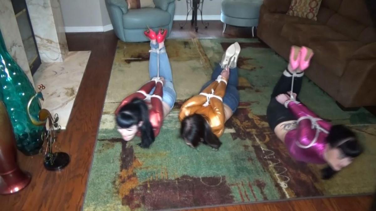 BRUNETTE HOGTIE TRIFECTA I've been hanging out a lot lately with Nyxon and Luna Dawn.  They keep chiding me about not living it up and call me a party pooper, so reluctantly I agree to try some weed.  They dress me to match them in skin tight jeans, shiny crop top and stiletto heels.  Off we go to meet Luna's connection and before we knew what was happening the three of us wound up brutally hogtied on the floor.  Our elbows were painfully crushed together and as much as we struggled, the bondage wouldn't budge.  I am really pissed off at them for getting me into this mess and I let them both know it.  Of course, Nyxon blames Luna and her shoddy connection and Luna blames Nyxon for not checking him out before we got here.  We bitch and yell at each other and suddenly our captor the XXXX dealer returns.  He waves a pair of panties in front of Nyxon's face, but all she cares about is whether he brought us the weed.  He stuffs the panties into her mouth as wraps her head around and around with clear tape.  Luna & I watch in XXXX knowing that we are next.  He straddles my bound body and shoves a large satin panty deeply in and seal it with lots of wraps of that horrible clear tape.  Luna cries out and apologizes, but it is way too late for that.  He moves over to luna and XXXX a panty into her mouth too and of course she gets many layers of tape wrapped around her pretty face.  He leaves the three of us completely helpless brutally hogtied and struggling rolling around the floor. 