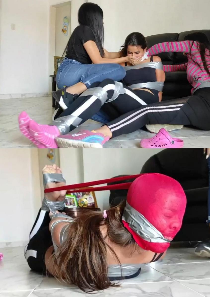 Duct Tape Tied And Turned Piggy Girl By An Effective Pair Of Team-Working Gals! 玛丽和阿里带着他们那被捆绑、塞住嘴的囚犯莱卡进入他们的房子，在那里他们全身心地投入到难以置信的团队合作中，迅速将莱卡变成一个绑着胶带、连裤袜的小猪女孩！Mary and Ari lead their feisty tied and gagged prisoner Laika into their house where they fully commit themselves to incredible teamwork to quickly turn Laika into a duct-tape bound and pantyhose hooded piggy girl!