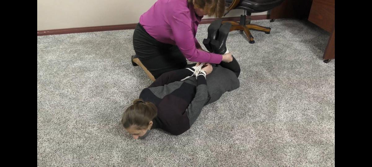 QT0960 Lera Grigio (is-qt-lg025) Lera Grigio is a customer service rep with a very bad attitude. But when one of her clients shows up in person and starts to tie her up, she tries to sing a different tune – at least until she is thoroughly gagged with duct tape! Despite being bound hand & foot, she tries to reach the phone on her desk, but only ends up more securely hogtied. Maybe next time she should be nicer to her customers!