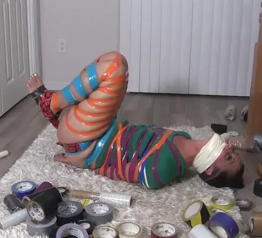  Fayth Stubbornly & Painful Escapes Lots of Tape pt 3 of 3 Knotty Guy把我绑在有史以来最鲜艳的粘猪圈里（上），然后他看着我在拍照时挣扎（下），现在是我决定做一些非常顽固和痛苦的事情的时候了。我慢慢地但最终还是插科打诨地和Knotty Guy说，我会逃离这条过度的胶带。他真的不相信我，但他退缩了，让我接受了这个不明智的想法。我的手腕上用胶带粘得很好，我真的不知道我是否能逃脱，但我越挣扎，我就越出汗，胶带也伸得越多，给了我一线希望。我只需要一只手，也许还有机会。哈我几乎大错特错。我设法腾出了一只手，但当我需要两只手才能把胶带从身上扯下来时，这对我没有多大帮助。当胶带慢慢地粘在我身上时，我做出了最真诚的表情。它很疼，我从OTM磁带插科打诨下面把它说出来。哎哟，哎哟，伸展，哎哟。我有什么建议我可以逃跑。现在我只是固执地向自己证明我能做到我说的话，即使这很痛苦。慢慢地但肯定地，一块一块地，一声一声地。。。我设法从这种荒谬的猪胶带中变得更自由、更宽松。我自言自语，孩子，我会告诉你我的感受吗？现在你听到的更多了，所以抱怨这胶带粘在我的皮肤上。我身体的某些部位比其他部位更疼。哇，我自己给了我一个多么神奇、几乎不可能的挑战。好吧，好吧，现在轮到你感受一下这条胶带有多粘！Knotty Guy has taped me in the most colorful sticky hogtie ever (Part 1), then he watched me struggle as he took pics (Part 2), now its time i decide to do something very stubborn and painful. I slowly but eventually gag talk to Knotty Guy that I will escape this excessive taped hogtie. He really doesn't believe me but he stands back and lets me at this not smartest idea. My wrists are so well taped with electrical tape, i really don't know if i can escape but the more I struggle, the more I sweat, and the more some of the tape stretches, giving me glimmers of hope. All i need is 1 hand free and maybe there's a chance. Ha...i am almost very wrong. I manage to get 1 hand free but really doesn't help me much when it takes 2 hands to rip, pull and stretch this tape off of my body. I make the most genuine faces as the tape slowly unsticks to my body. It hurts and I make it known from beneath my OTM tape gag. Ouch, Ouch, stretch, Ouch. What did I even suggest that i could escape. Now i'm just being stubborn and proving to myself I can do what I say, even if it hurts pretty badly. Slowly but surely, piece by piece, grunt by grunt...I manage to get freer and looser from this ridiculous hog taping. I ungag myself and boy do I tell you how I feel and now you hear me more so complain how sticky this tape is on my skin. There are certain parts of my body it hurts much more more than others. Wow, what an amazing almost impossible challenge i self gave. OkOk, now its your turn to feel just how sticky and stuck this tape can get you!