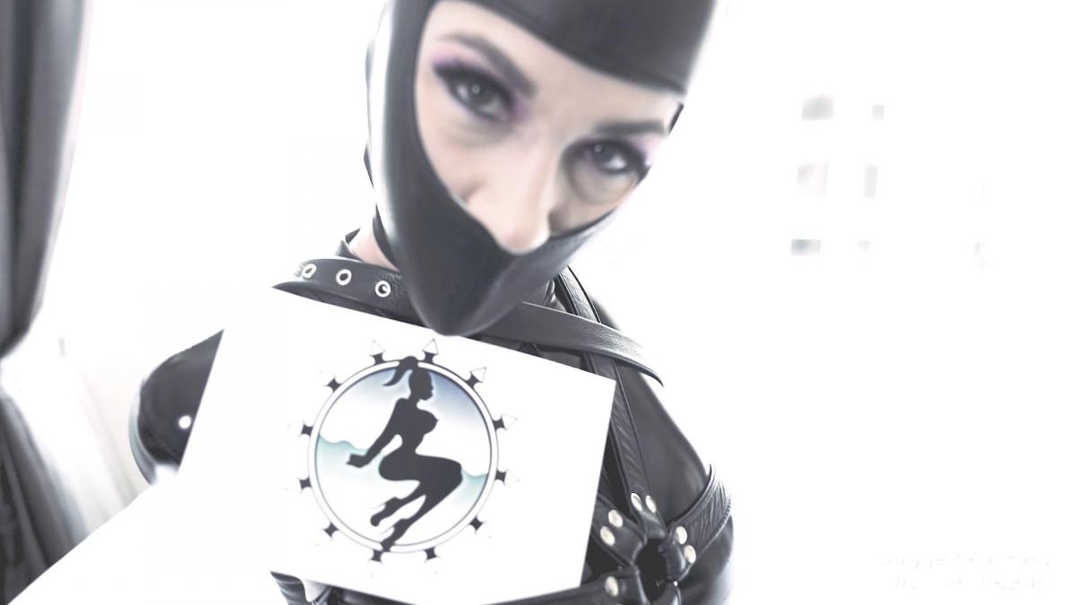 Terra Mizu Fetcon Live Logo This video was shot during Fetish Con 2022. Terra Mizu came to our shoot, we tried on a PVC catsuit and several leather bondage items—body harness, Gwendoline hood. During the shoot we saw the logo of Fetish Con and decided to make a parody of it. I just so happen we have all the equipment in the logo—hood, armbinder, and even pleaser shoes. The video starts with Terra getting strapped in: leather body harness, self gagging using microfoam tape, and applying the leather hood herself. We tie up the hood for her and strap her in with the leather armbinder. The scene then cuts to Terra squirming and struggling on the bed. The she sits up and tries her best to imitate the logo and even decides to make a tiktok video out of it! Several takes of the tiktok video making are shown to pic one out of the many. In the end she is freed and showcases her lip print on the tape…