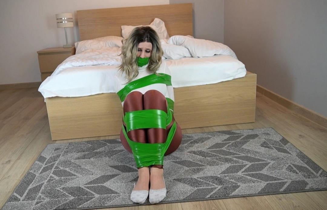Green Tape Bondage VIDEO Pinkie is wearing her bronze spandex pants, white turtle neck and white converse shoes. She is taped on the floor with green tape. she is also wrap gagged with the same super sticky green tape.