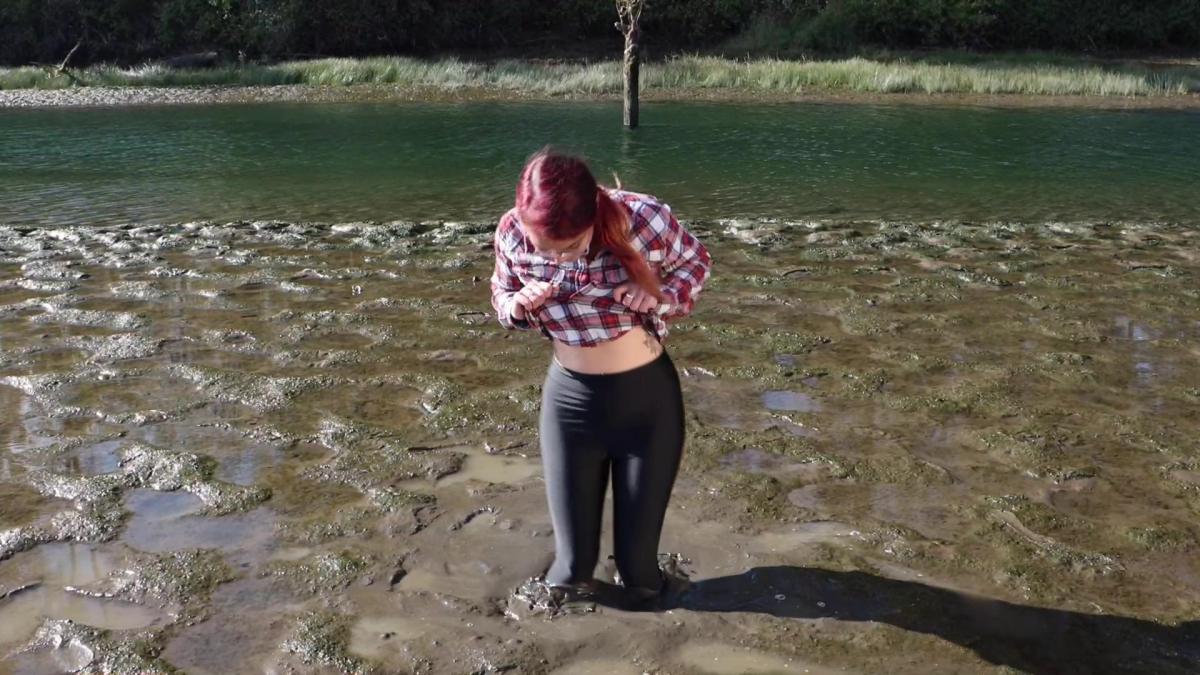 QS I Heart U Baby Filth makes her return to the quicksand in this wonderful movie, shot on a breezy fall day truly the last day of the year to be get outside and get filthy. In a simple pair of nylon black leggings and a sports bra with a flannel shirt, she explores the water's edge, looking for a soft spot. She soon finds one, and begins bouncing up and down on the surface of the quicksand as if it were a trampoline. Slowly, the sand agitates enough and she starts to break through and begin sinking. She is truly giggling with sheer delight as she sinks down deeper and deeper. She twists and turns, flailing her arms and corkscrewing her body to push herself in deeper. Finally at about chest deep, she takes her well-manicured hands and digs in, so she is chest deep. After revealing the nature of her relationship with the slurping, bubbling ooze, she slowly crawls out. Baby Filth loves her quicksand, and this movie shows it!