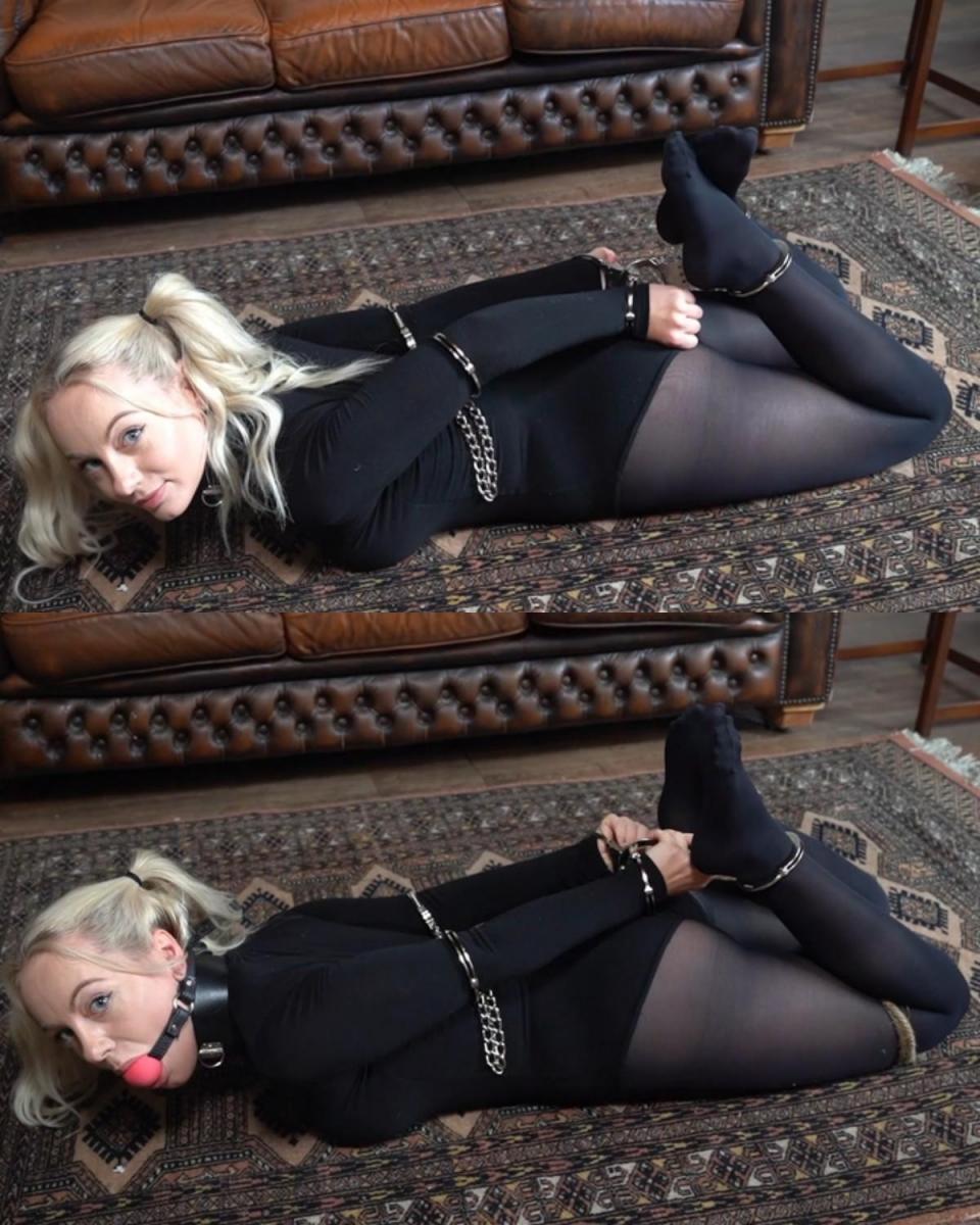2179 Chloe in Hogcuffed Display 克洛伊穿上全黑尼龙套装。 三个坚硬的手铐被用来铐住她。 她的肘部增加了更多手铐，还有一个球口。Chloe puts a full black nylon outfit on. Three rigid cuffs are used to hogcuff her. More cuffs are added to her elbows and also a ballgag.