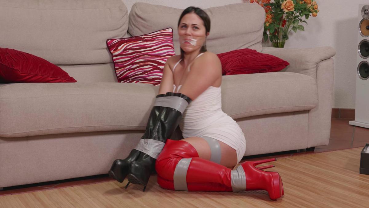 Mia and Pamela - Bootcamp (ultraHD) the scene to start with Mia walking in, sitting down and putting on the red boots she just bought.<br>She admires them for little, then she then begins playing on her tablet. Next to the sofa is the pair of black boots Mia has worn previously. She's going through her phone when a female assailant comes in. She's wearing a balaclava. She doesn't say a word. She hands Mia a note and it says :<br>"People have my step-sister. If I don't do what they say they will keep her. I have to tie you up and rob your house."<br>Tha assailant raise her balaclave and shows her mouth is sealed with a gag Mia puts her hands up in surrender. The assailant stuffs a sock in Mia mouth and cleave gags her with a wrap around<br>clear pvc tape gag. Once she's wrapped the cleave twice she then closes her lips together to continue wrapping with the tape. Once she's finished gagging her she uses her black boots and slides them over Mia's hands and arms like gloves.<br>The assailant then tapes Mia's hands in the boots in front of her and she wraps tape around her upper body. She then proceeds to tape Mias legs and thighs with tape and leaves her to go rob the house. After the custom clip is over what follows is a boots/legs/feet showoff by Mia and Pamela (finally unmasked). They wear Minidresses while their slowly show us their booted legs before unlacing their boots and finally going barefoot