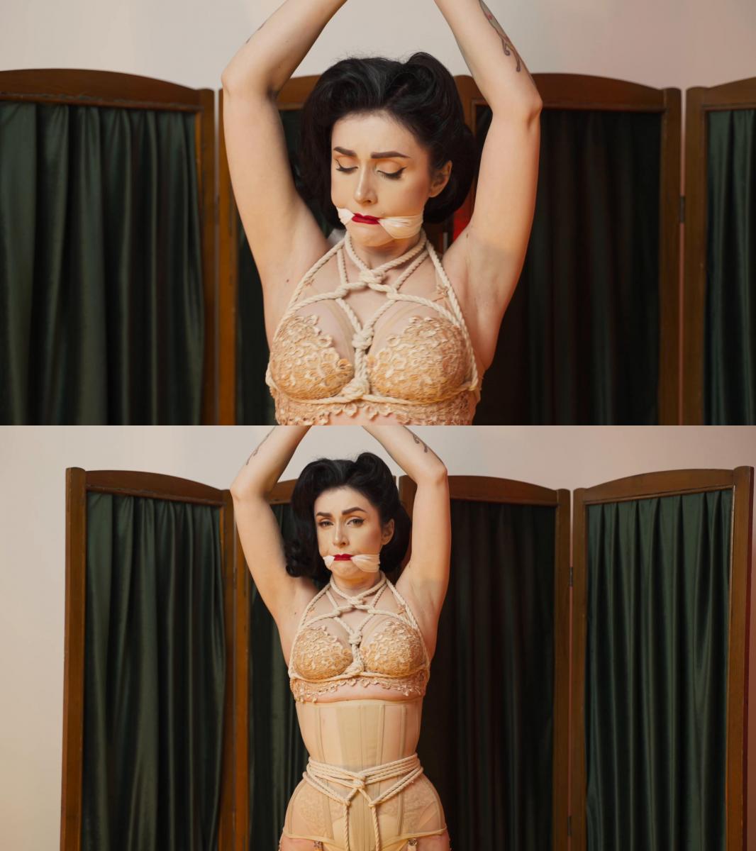 Vintage style and rope bondage 现在就进入复古时代 - 在您面前的是上世纪 50 年代恋物杂志最佳传统中的海报女郎风格美女。 她被束缚而无助，她呻吟着并试图挣脱。 她的双臂被吊着绑着，她完美的身体被紧身胸衣包裹着，尼龙丝袜完美地凸显了她修长的双腿。 立即欣赏此视频<br><br>Plunge into the retro era right now - in front of you is a pin-up style beauty in the best traditions of fetish magazines of the 50s of the last century. She is bound and helpless, she moans and tries to break free. Her arms are hung and tied, her perfect body is wrapped around a tight corset, and her nylon stockings perfectly emphasize her slender legs. Enjoy this video right now