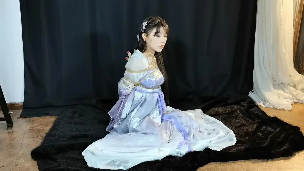 嫣儿国风汉服后高手十指分指缚 勒嘴驷马吊 嫣儿国风风格作品《紫色孔雀开屏汉服》嫣儿装扮一袭淡紫色汉服肉丝裸足，日式后高手胸缚加进一些变化将十指分指缚，脚踝处的绳子绕到后手腕处固定形成驷马倒攢蹄，用绳子吊起上半身后让嫣儿张开嘴，将绳子绕过嘴紧紧的缠绕两圈再固定到背后的吊缚绳上，之后便静静欣赏被驷马吊缚放置的嫣儿。<br>头像右侧点击视频进入主页，关注更多嫣儿最新绳艺TJ作品。