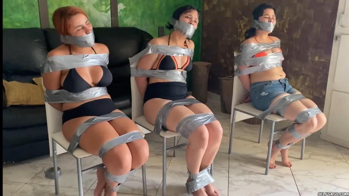 Three Bikini Girls In Tape Bondage 3 girls return home from the beach when some creep who studied the sexy bikini chicks on the beach shows up at their front door. We see the ladies duct tape bound and tape gagged in each their separate rooms where they struggle for release. During each desperate attempt to escape, the bound bikini girls find each other reunited in the living room where they are caught by the creep again, chair tied and each tape gagged tighter! Will the 3 bondage girls escape?